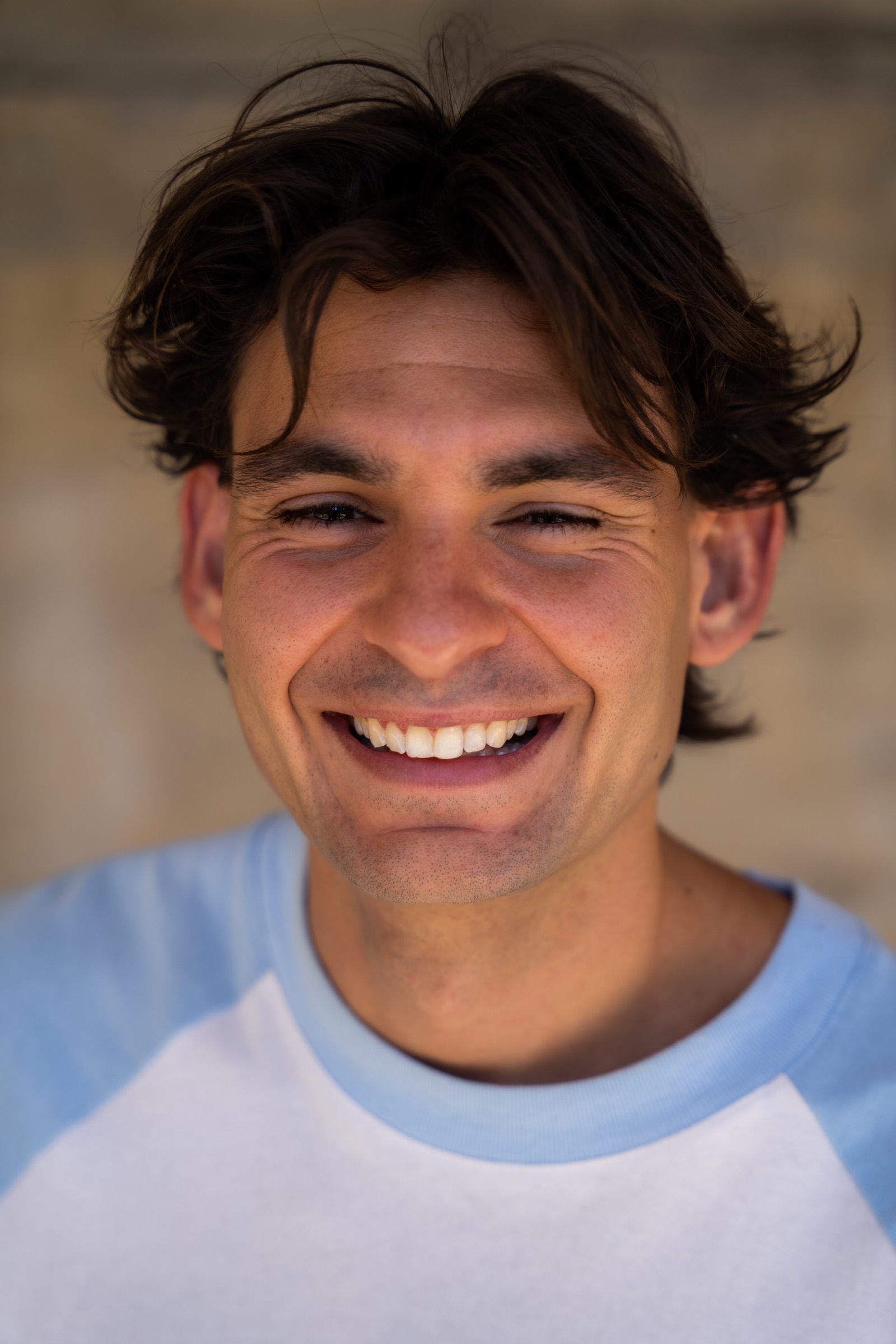 Portrait session, natural laugh against a brick wall